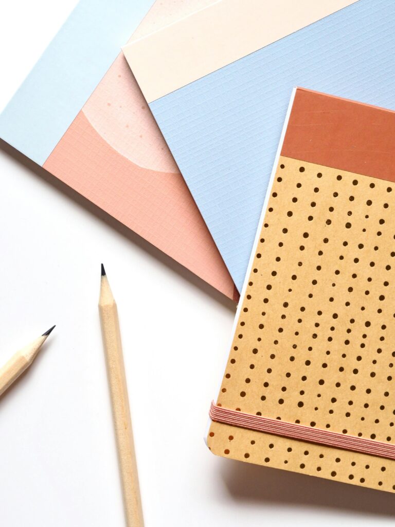 pexels-photo-1764436-1764436 Colorful notebooks and pencils arranged neatly for a creative workspace.
